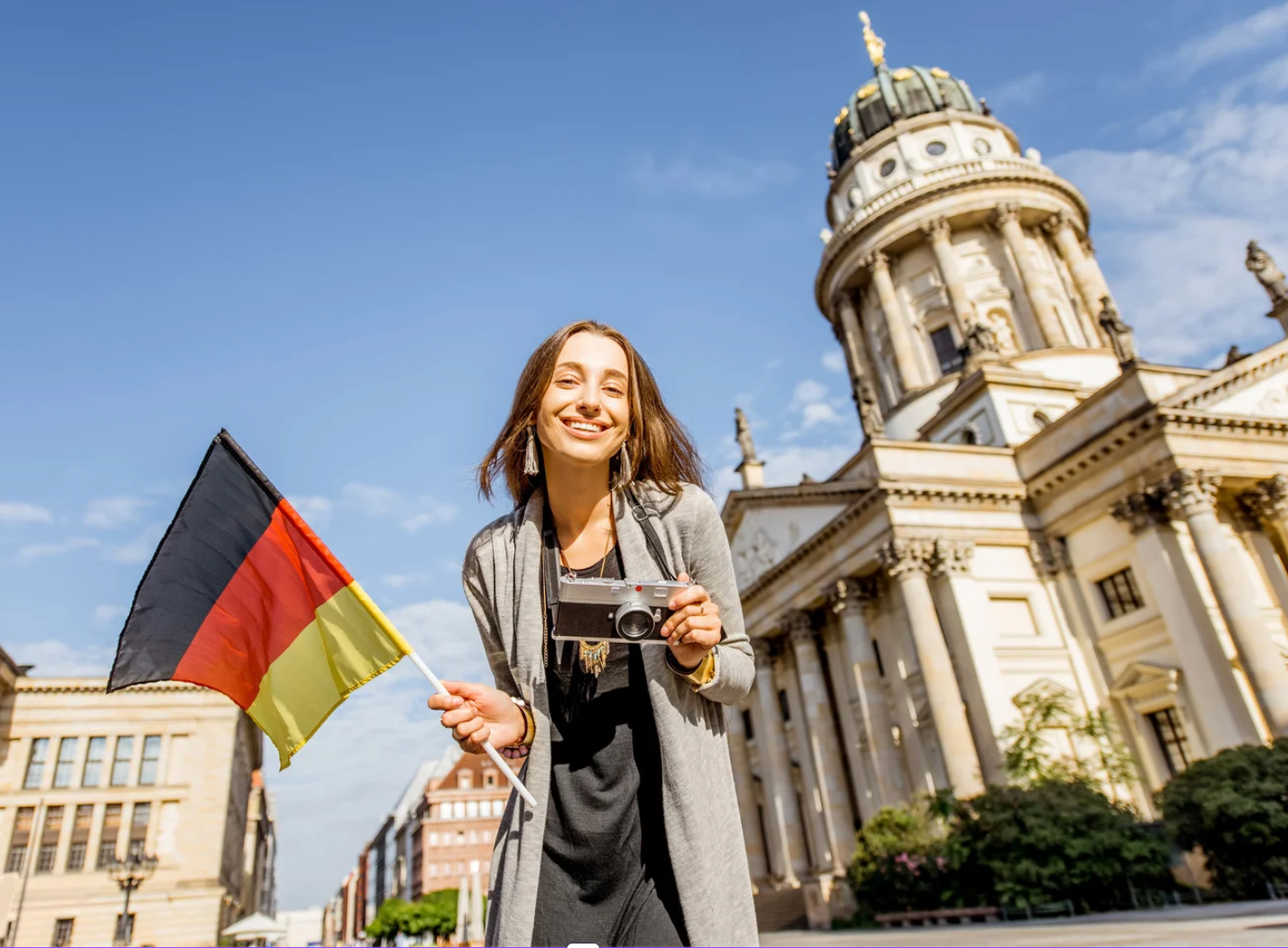 Viajera con una bandera alemana y una cámara en Alemania