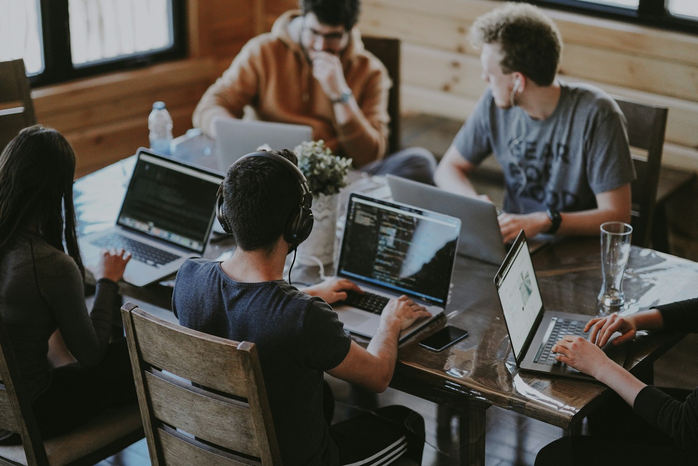 Equipo colaborando con computadoras en un entorno profesional